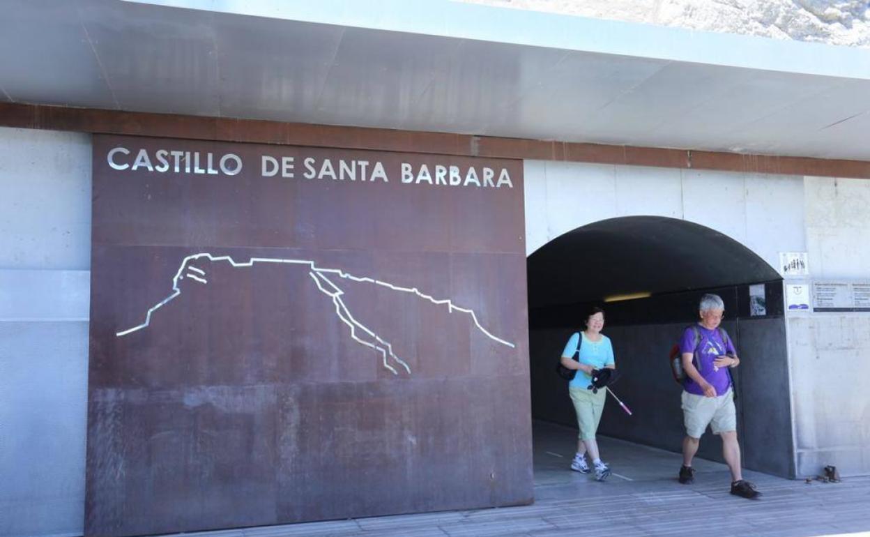 Dos turistas salen del túnel que da acceso a los elevadores. 