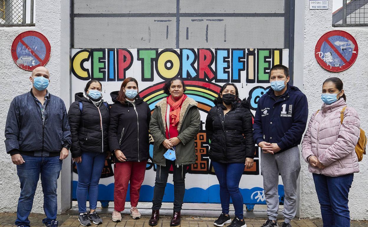 Padres y madres de niños afectados por la falta de educadoras junto al colegio. 