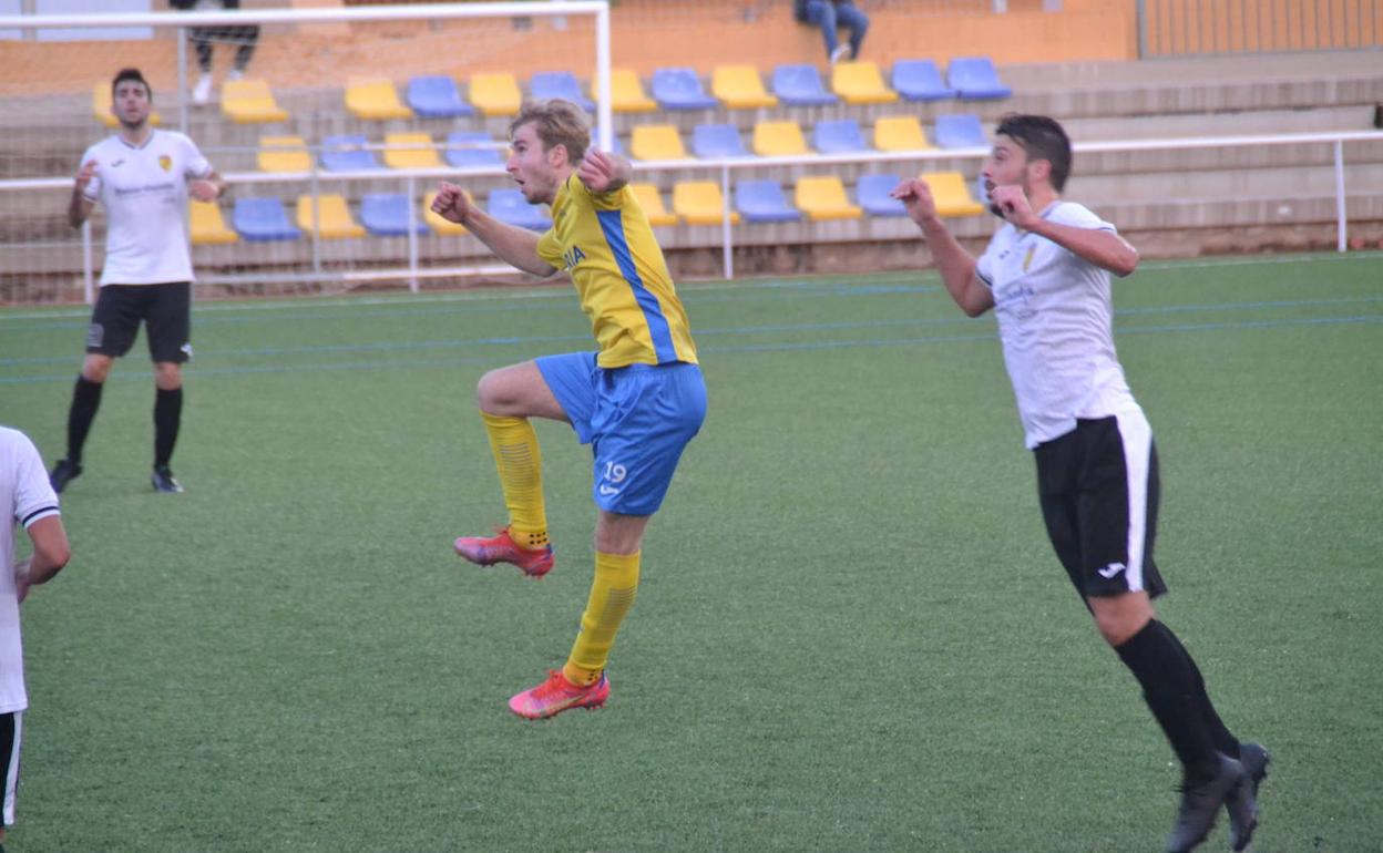 El jugador groguet Renzo saltando a por un balón. 