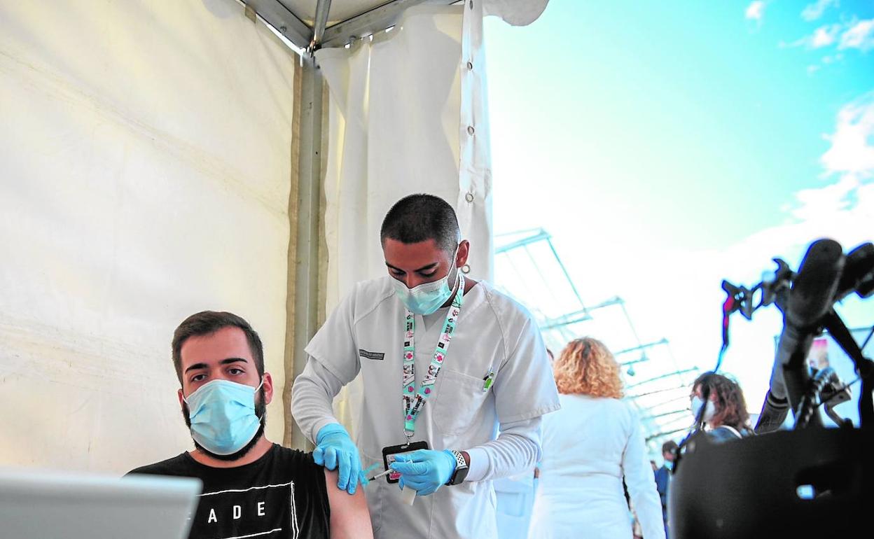 Un joven se vacuna en el centro de inmunización móvil instalado con motivo del festival de música de Les Arts.