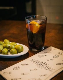 Imagen secundaria 2 - Arriba, estantería de vermuts del Bocatín del Carmen. Abajo a la izquierda, vaso de vermut de la taberna Pare Pere. Abajo a la derecha, vaso de vermut del Bar Bermúdez