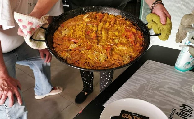 Imagen principal - Arriba, arroz a banda preparado en el bar Gran Torino. Abajo a la izquierda, minihamburguesas de figatell del local. Abajo a la derecha, puchero de pulpo del bar,