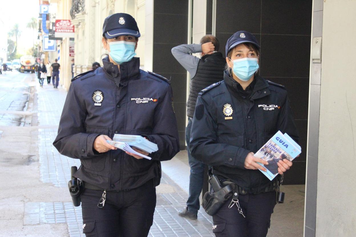 Miembros de la Policía Nacional con el folleto informativo del 'Plan de Comercio Seguro'. lp