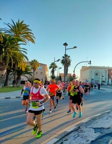 Imagen secundaria 2 - Arriba, los corredores a su paso por la calle Eugenia Viñes. Abajo a la izquierda, Pilar con la bandera valenciana y la de la Isla de Wight. Abajo a la derecha, los corredores pasando por la Avenida de los Naranjos. 