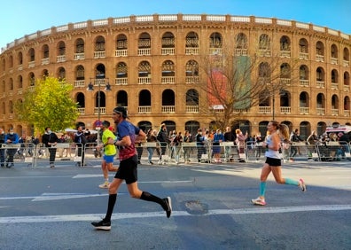 Imagen secundaria 1 - Arriba, corredores a su paso frente a la plaza de Toros. Abajo a la izquierda, unos deportistas pasan frente a la plaza- Abajo a la derecha, la Maratón a su paso frente a la Estación del Norte. 