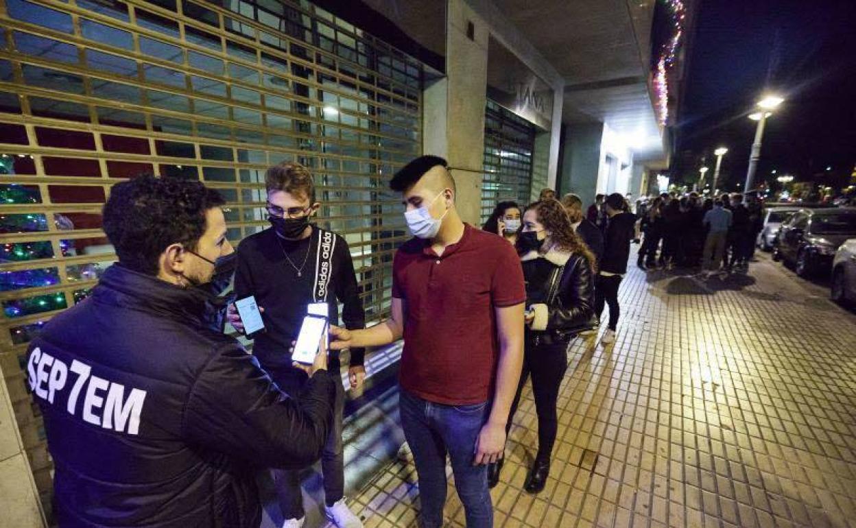 El seguridad de una discoteca pide el pasaporte Covid a los clientes. 