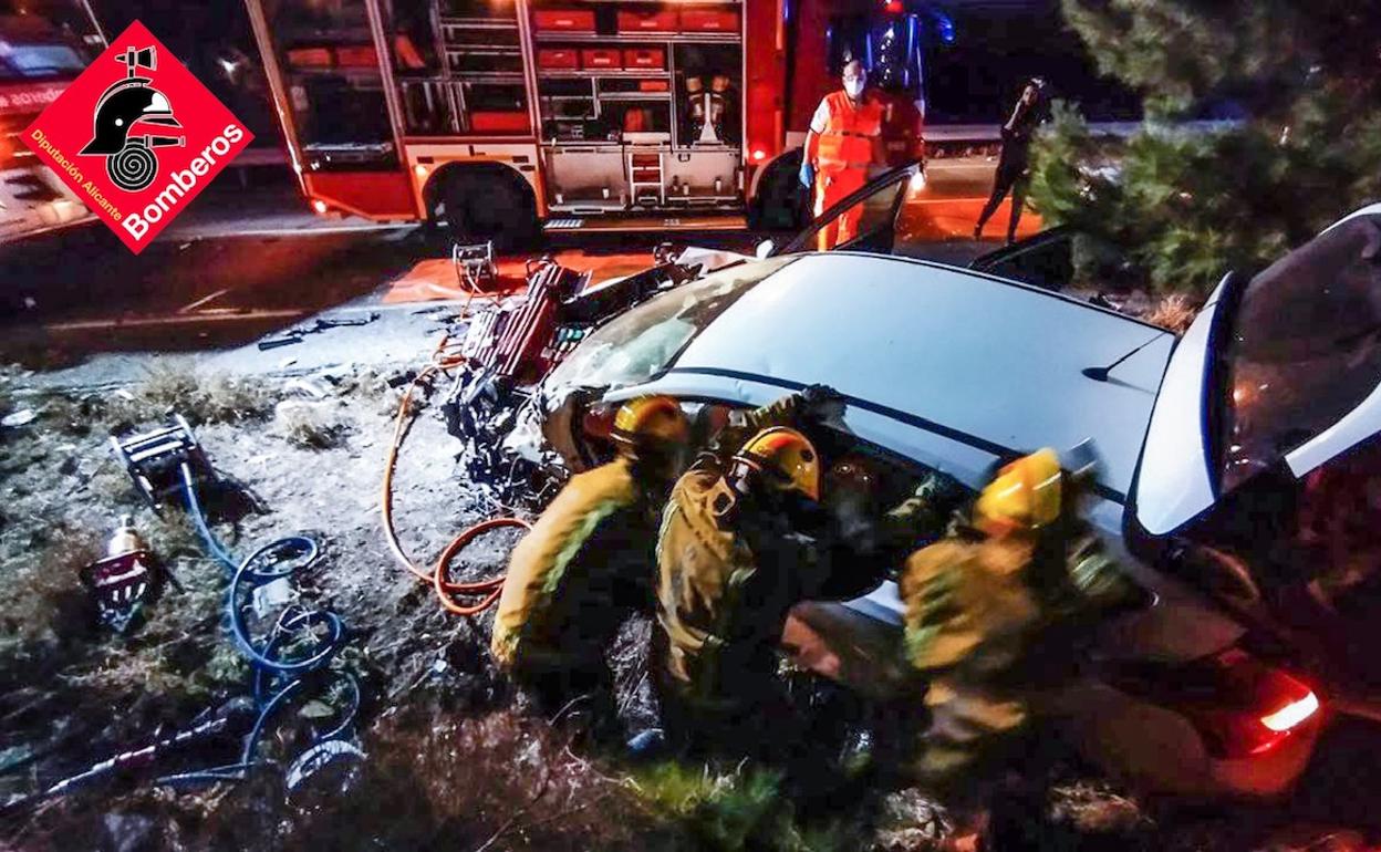 Los bomberos trabajan en excarcelar al conductor atrapado en el vehículo. 