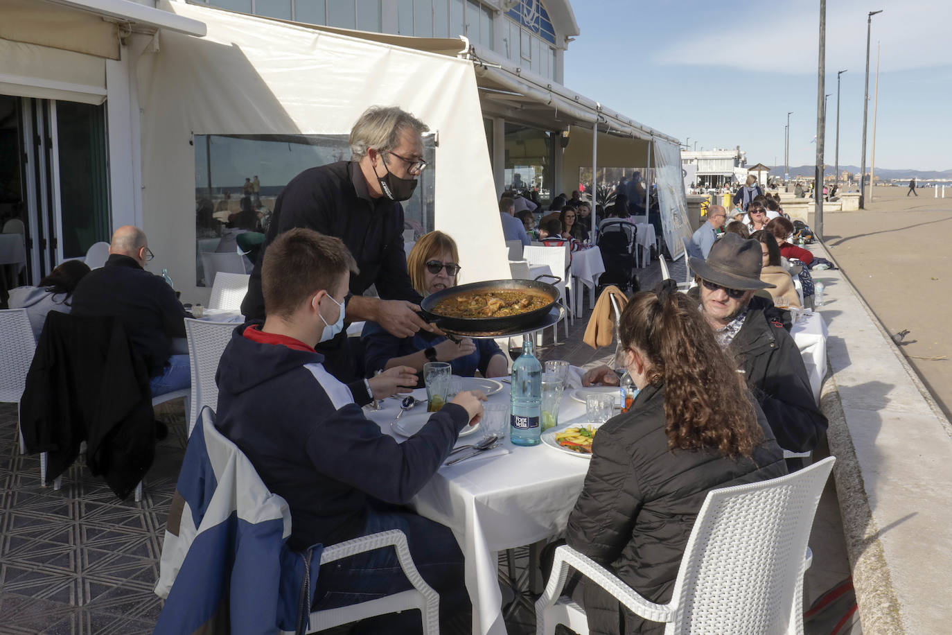 El sol y las buenas temperaturas animan a salir a la calle tanto en el centro de la ciudad como en el paseo marítimo. La hostelería valenciana comienza a pedir el pasaporte Covid, las terrazas se llenan de clientes y cualquier punto de la capital es bueno para pasear.