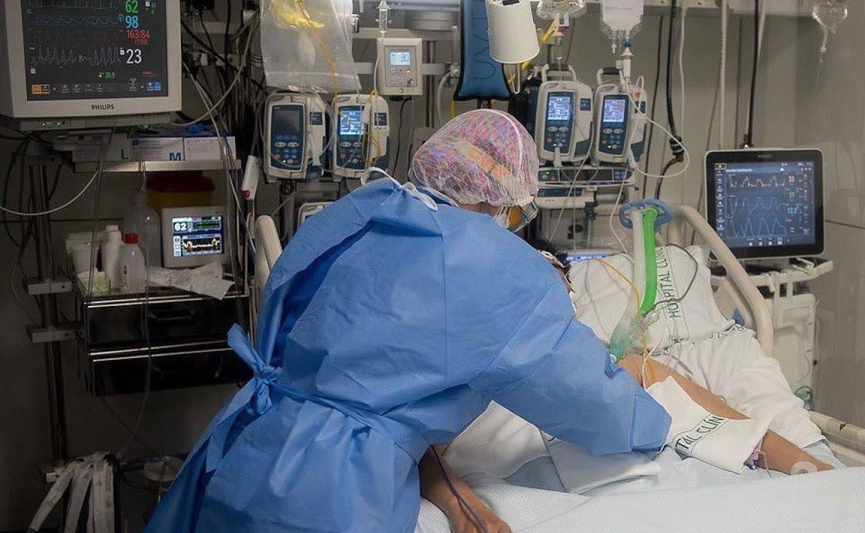 Una sanitaria atiende a un paciente en un hospital. 