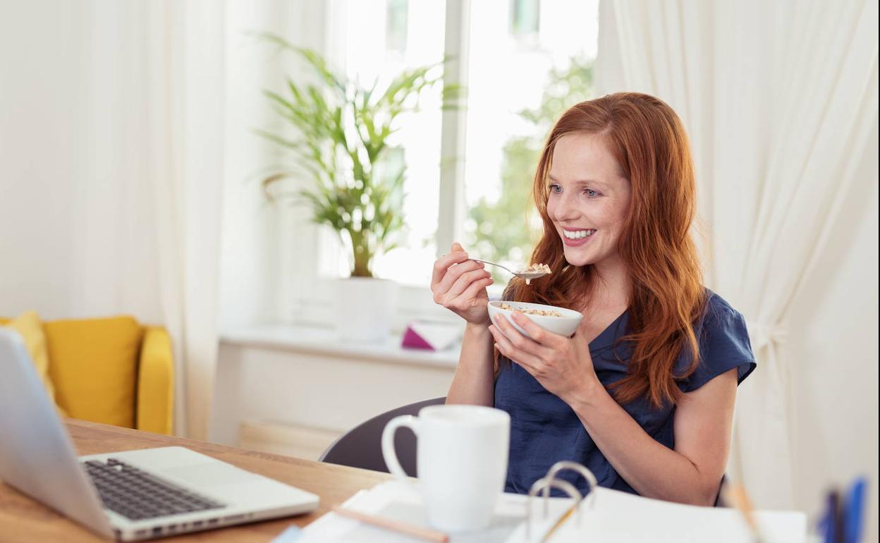 Una chica desayunando.