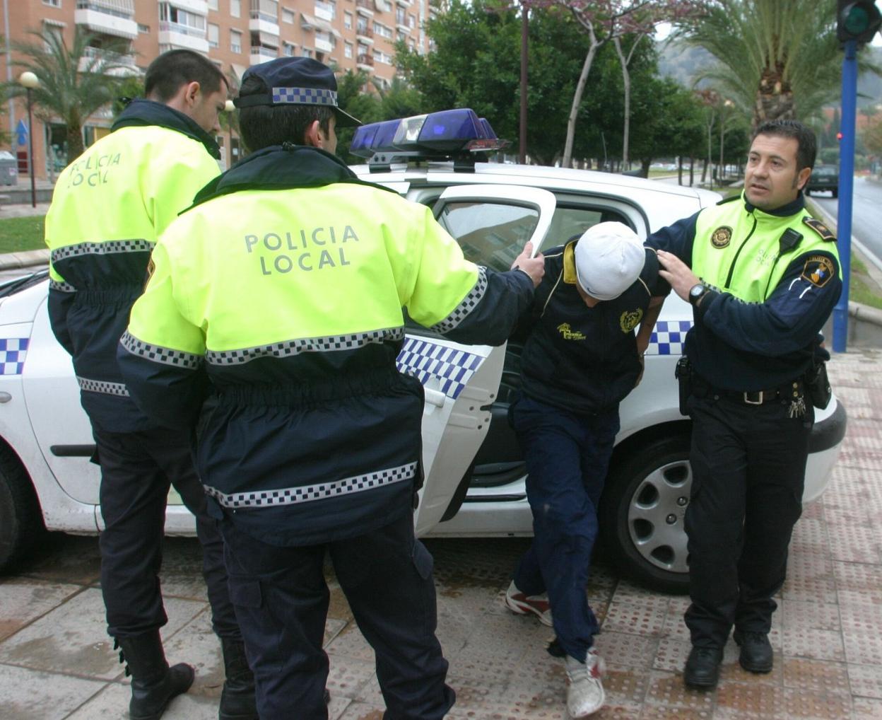 Policías locales de Alicante trasladan a un menor detenido, en una imagen de archivo. álex domínguez