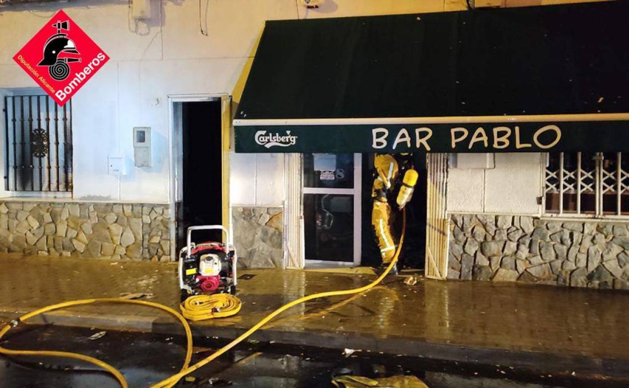 Intervención de los bomberos en el bar incendiado este domingo en Almoradí. 