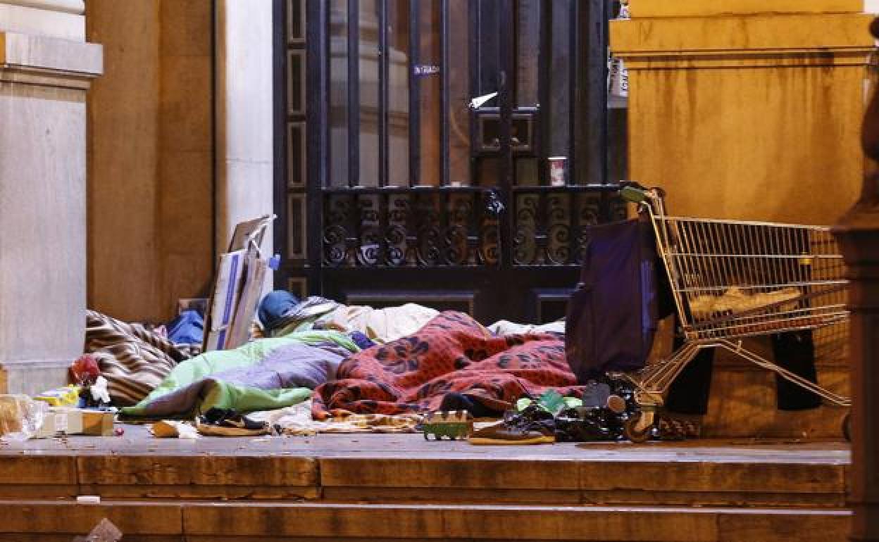 Personas sin techo duermen junto al antiguo edificio de Hacienda. 