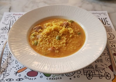 Imagen secundaria 1 - Arriba, barra del bar Birlibirloque con una muestra de los vinos tintos que tienen en su catálogo. Abajo a la izquierda, plato de arroz meloso con pollo y habitas baby. Abajo a la derecha, croquetas de jamón del bar.