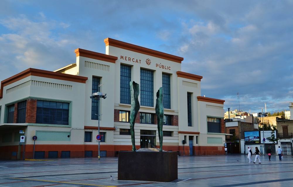 Al sur de la capital catalana, y orillas del Mediterráneo, encontramos a Vilanova y la Geltrú y a su Mercado del Centro, un espacio magnífico para disfrutar mientras llenas la cesta de productos frescos que los vendedores y productores ofrecen recién llegados de la huerta y el mar. En total son 78 puestos, entre los que encontramos bacaladerías, pescaderías, carnicerías, queserías, panaderías, verdulerías y herbolarios entre otros muchos productos de altísima calidad. Sin embargo, aquí el producto estrella es el pescado y el marisco, que llega todos los días del mar que se encuentra a pocos metros. Además, este mercado nos sorprende con una iniciativa muy interesante para comprar de una forma más sostenible, por ejemplo, usando bolsas reutilizables, comprando las bebidas a granel o llevando las hueveras de casa. Y es que además de ser sostenible, los clientes más implicados tienen unos buenos premios esperando.