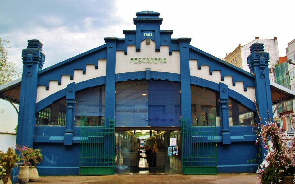 Entre astilleros y pescadores, a pocos metros de las frías aguas del Atlántico encontramos el mercado de la Magdalena, uno de los lugares más concurridos de Ferrol. Un mercado de alimentación, donde se pueden adquirir todo tipo de productos frescos y perecederos, pero curiosamente no hay puestos de pescado. Y es que como ocurre en toda Galicia, el pescado y el marisco son el producto estrella de estas tierras, que se merecen ser vendidos en un lugar especial. Así pues, aquellos que deseen tener en la mesa de Navidad unas buenas gambas, unos bogavantes o percebes tendrán que cruzar la calle para encontrar el edificio de la Pescadería, un bonito edificio de estilo modernista donde se pueden comprar los mejores pescados y mariscos a un excelente precio. Además, para aquellos que las compras les hayan dejado sin energías cuentan con un concurrido bar en el que sirven raciones exquisitas de los propios productos del mercado.