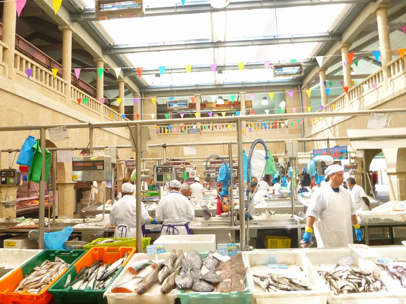 El mercado central de Pontevedra es un edificio de estilo tradicional gallego, con columnas y arcos de piedra que albergan 214 puestos de comerciantes, quienes abastecen diariamente la ciudad de Pontevedra con el mejor producto fresco. Todos los días los pasillos de este mercado son un ir y venir de gente. Hay quienes en estas fechas ya buscan el mejor pescado, marisco, carne o verduras. Pero también hay visitantes de todos los puntos de la península que sienten curiosidad por entrar en este mercado en búsqueda de la más famosa materia prima gallega: el pulpo. Incluso para los más impacientes, tienen la opción de comprar el producto fresco en la plaza y cocinarlo in situ en uno de sus puestos gastronómicos tal y como se haría en cualquier hogar gallego. Además, no te olvides de pasar por la lonja de Pontevedra, donde se realizan subastas de pescado y marisco, y que también podemos encontrar en el mismo edificio.
