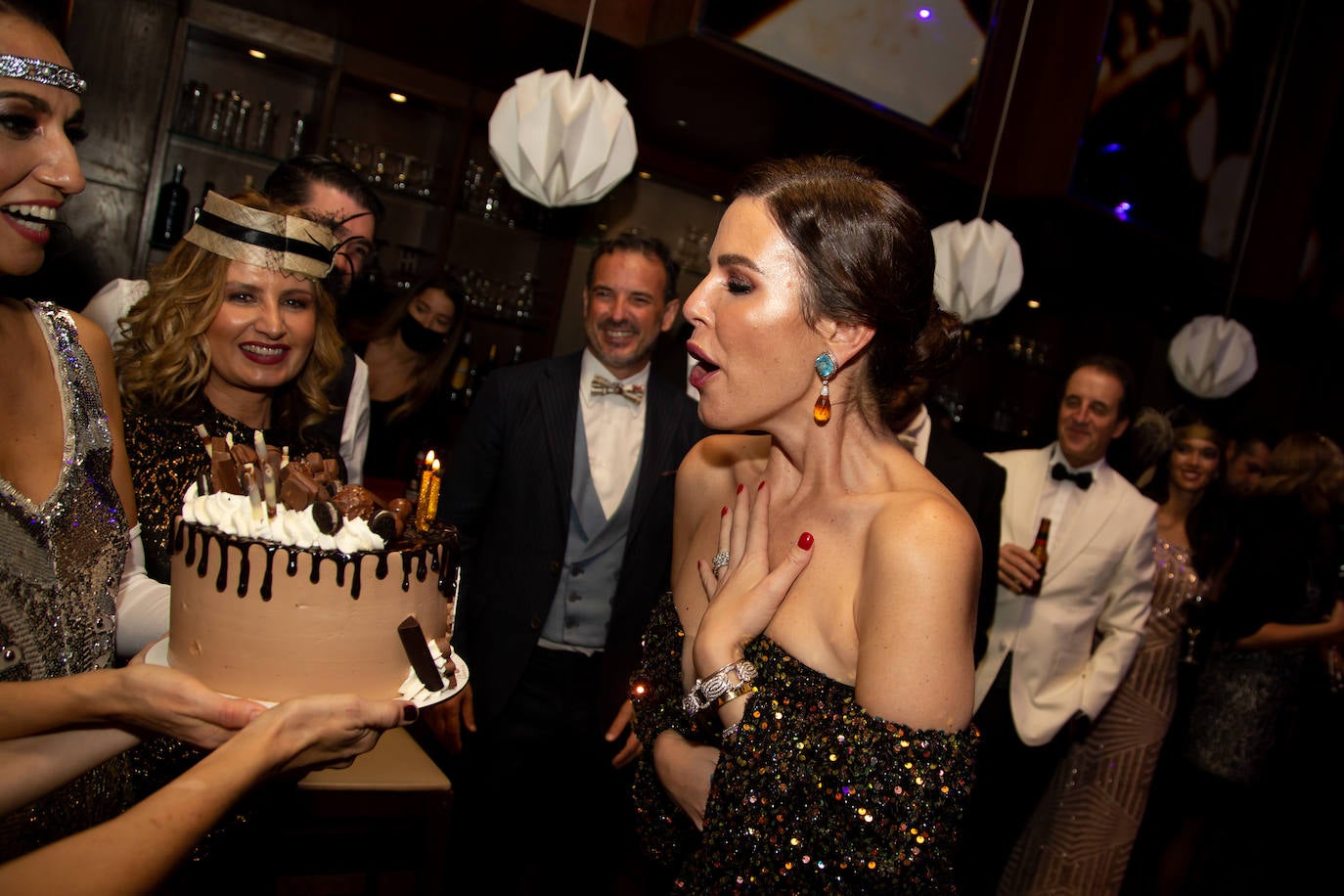 Ana García Rivera soplando la tarta que le regalaron sus amigas. Al fondo, Javier Edo y Eva Alapont.