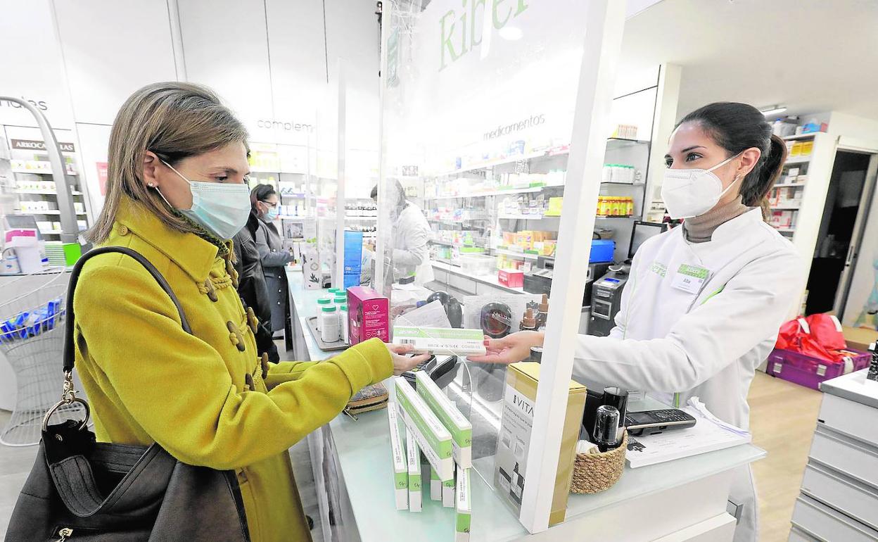 Una clienta compra una prueba de antígenos en una farmacia.