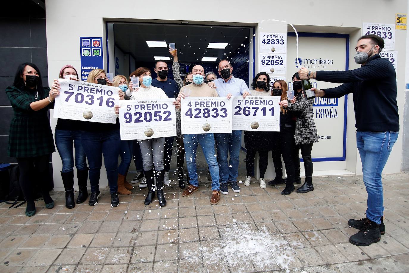 Trabajadores y vecinos de la administración número 3 de Manises, sita en la calle Maestro Guile, celebran la venta de los cuatro premios