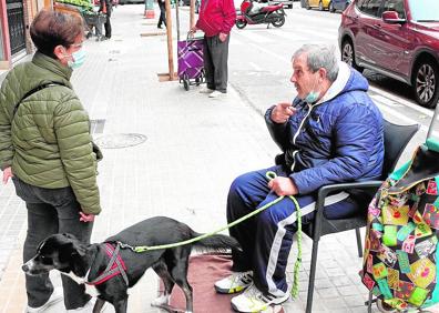 Imagen secundaria 1 - Negocios. Dos peluqueras atienden a una clienta #en un local del barrio de Marxalenes.| Pobreza. Un hombre pide dinero a las puertas de un supermercado en Marxalenes.| De acogida. Magalí es una inmigrante de Ecuador que vive y trabaja en el barrio.