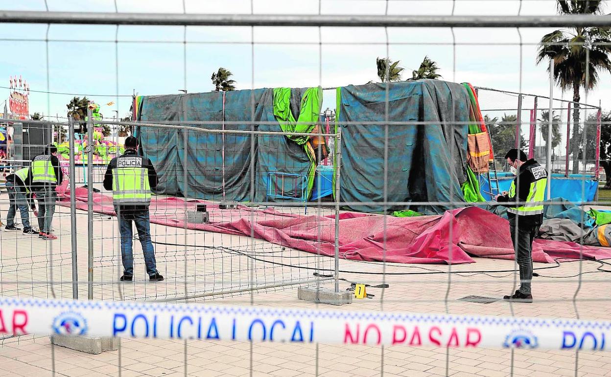 Cuatro policías inspeccionan el recinto donde tuvo lugar el accidente. 