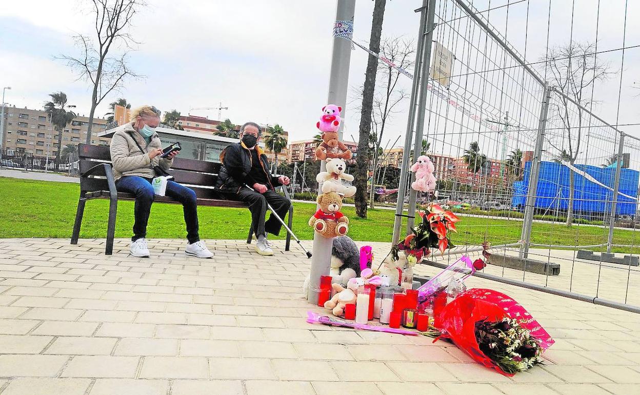 Peluches, velas y ramos de flores recuerdan a las dos niñas fallecidas junto a la valla que delimita la zona del castillo hinchable, este lunes, en Mislata. 