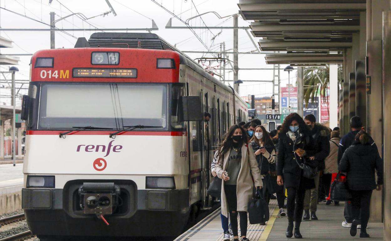 Viajeros junto a un tren de Cercanías en la estación del Norte. 