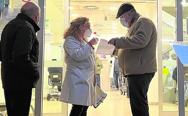 Las dudas. Una celadora atiende a un paciente a las puertas del centro de salud de Nou Moles. La presión asistencial en la atención primaria crece con el nuevo protocolo frente al Covid. 