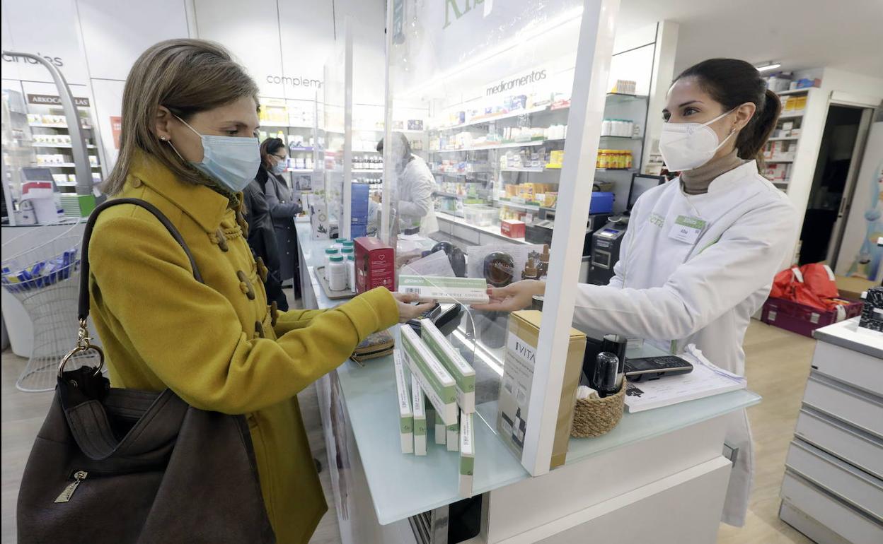 Una mujer adquiere un test de antígenos en una farmacia valenciana.