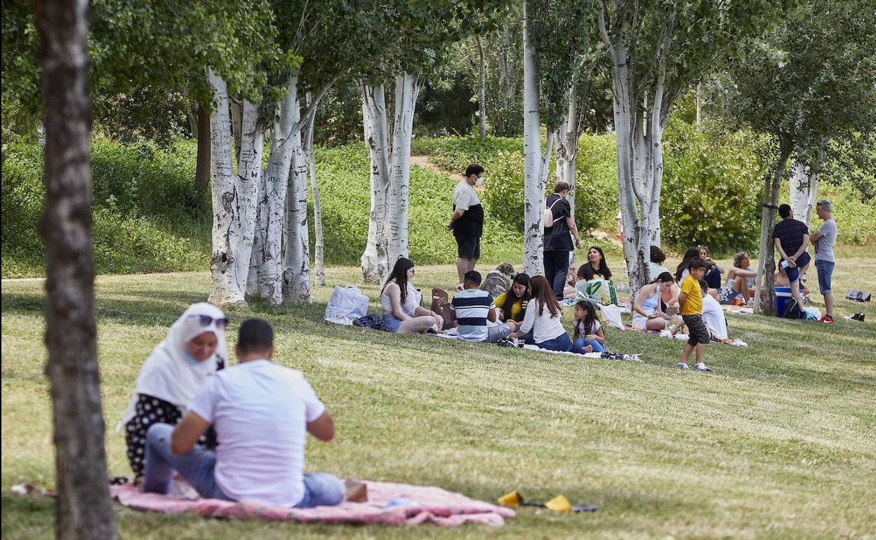 Varias personas hacen picnic en el cauce del río.