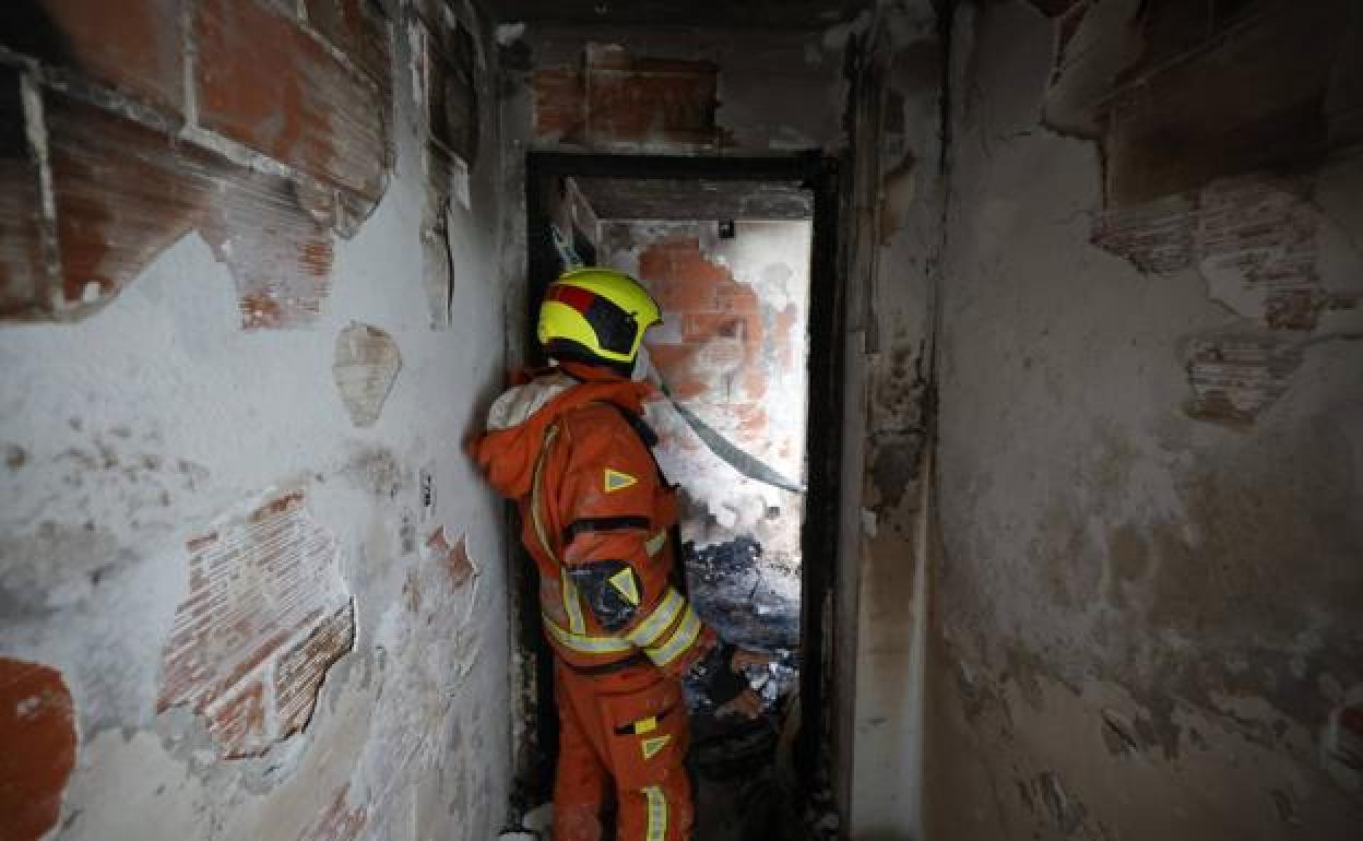 Un bombero, en la vivienda incendiada. 