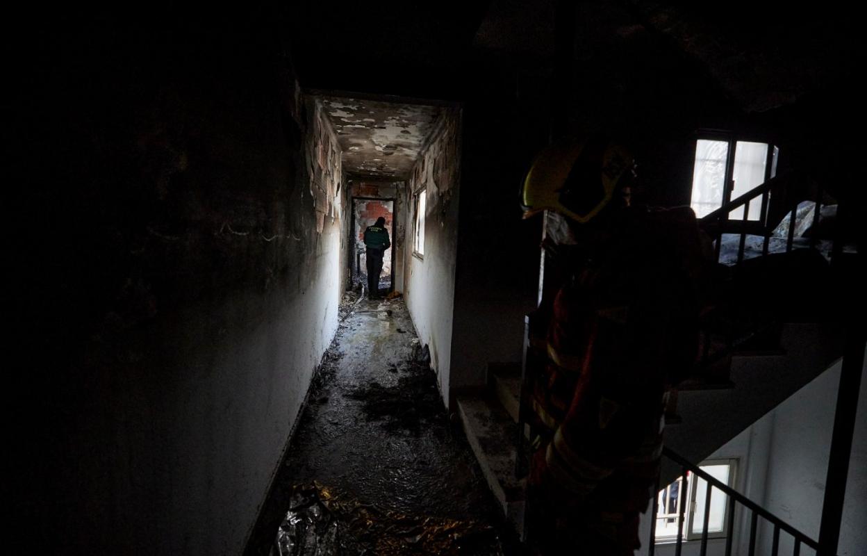 Un agente de la Guardia Civil, en el pasillo de la casa en la que fallecieron ayer una madre y su hijo. iván arlandis