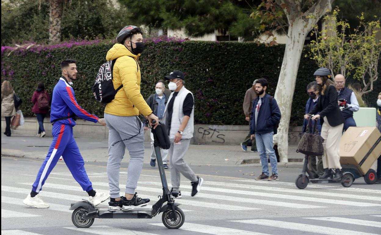 Un joven circula con patinete por el centro de Valencia.