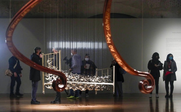 La barandilla de una escalera de caracol, colgada desde el techo, con los versos en bronce de San Juan de la Cruz. 