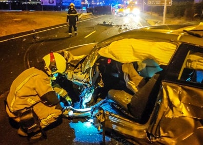 Imagen secundaria 1 - Los bomberos rescatan al camionero atrapado tras el accidente. 