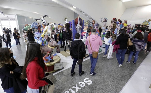 Imagen principal - Asistentes a la Exposició, ninot con una Virgen haciendo una peineta y gente retratando figuras. 