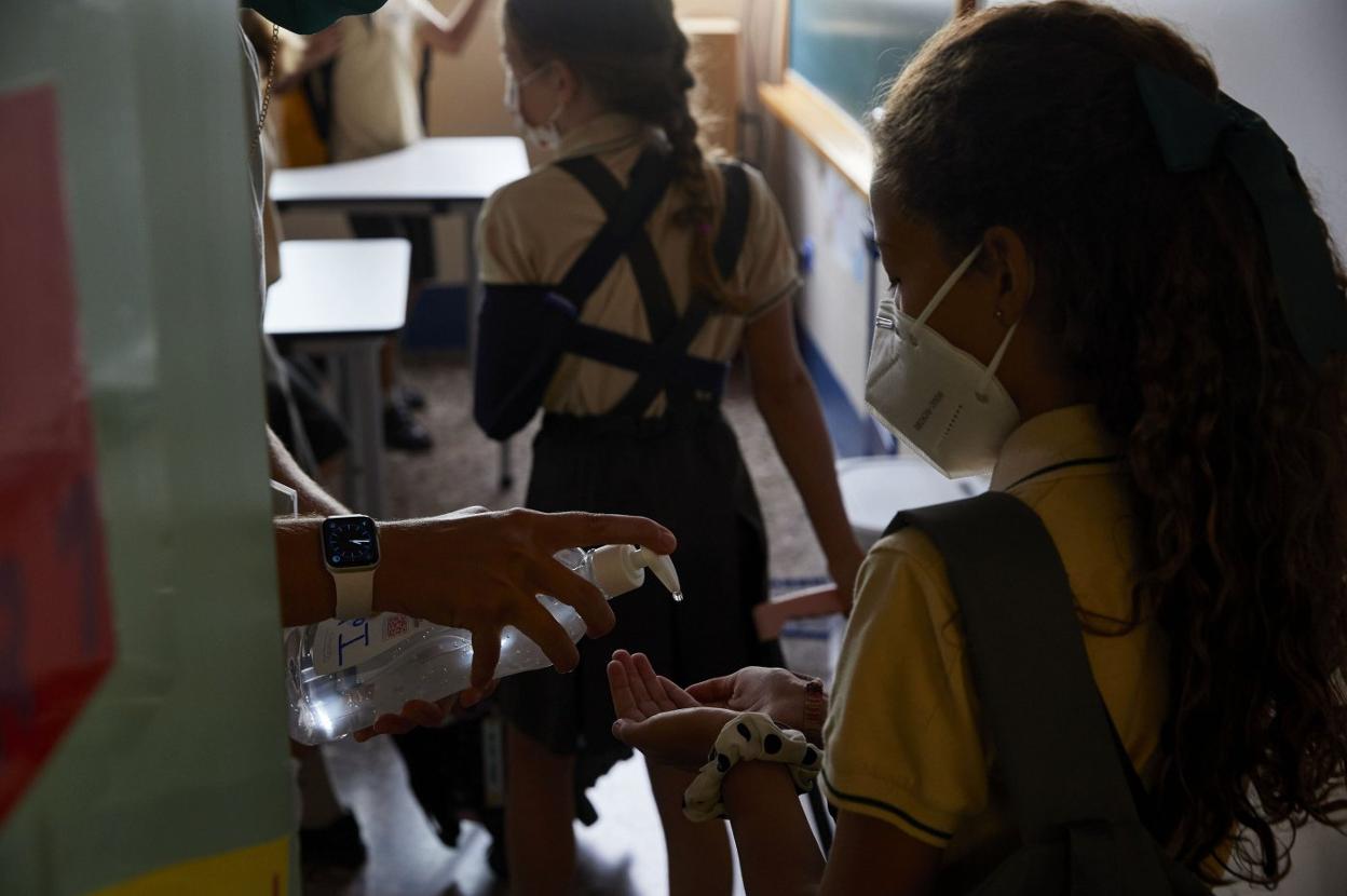 Una profesora ofrece gel a los alumnos de un colegio de Bétera. iván arlandis