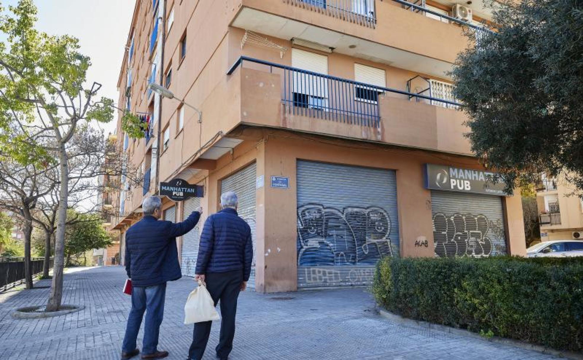 Dos vecinos observan el pub en cuyas cercanías falleció un hombre el domingo.