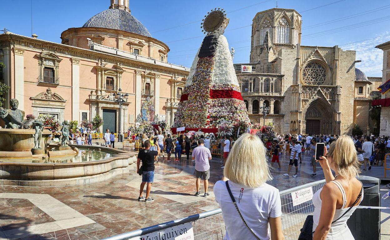 Un par de turistas sacan fotos de la Verge en las Fallas extraordinarias de septiembre del año pasado. 