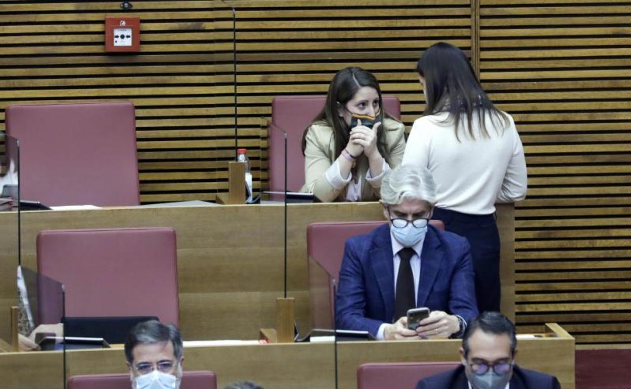 La diputada del PP, Beatriz Gascó, de espaldas, hablá en Les Corts, con la síndica de Vox, Ana Vega, tras la bronca. 