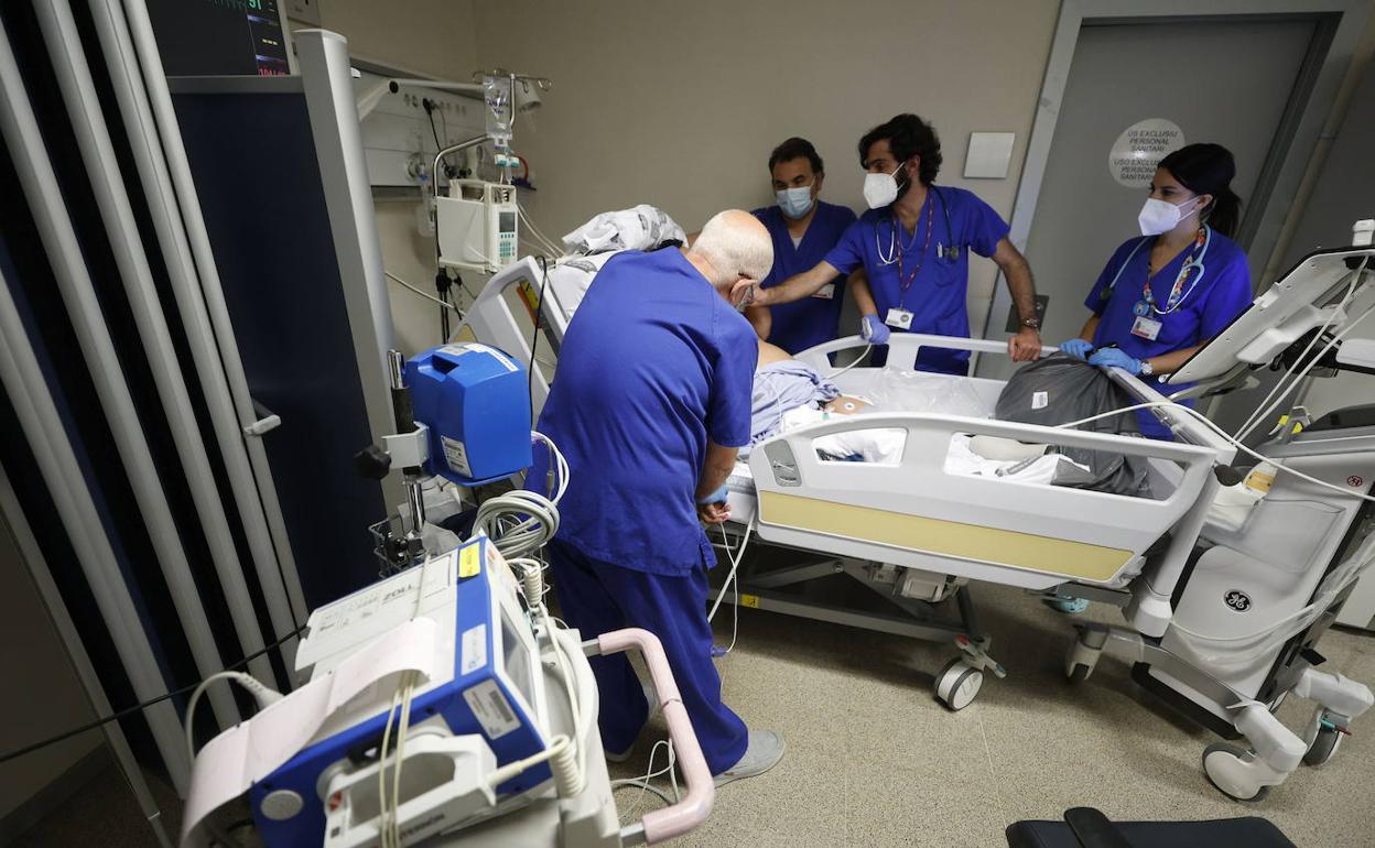 Varios sanitarios atienden a un paciente con coronavirus en el Hospital La Fe de Valencia. 