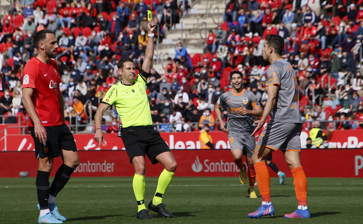 El árbitro amonesta a Gabriel Paulista, ayer en el encuentro contra el Mallorca. 