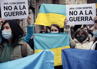 Imagen secundaria 1 - Parte de la comunidad ucraniana de Valencia se concentra en la plaza de la Virgen en protesta por la guerra iniciada por Rusia en Ucrania. 