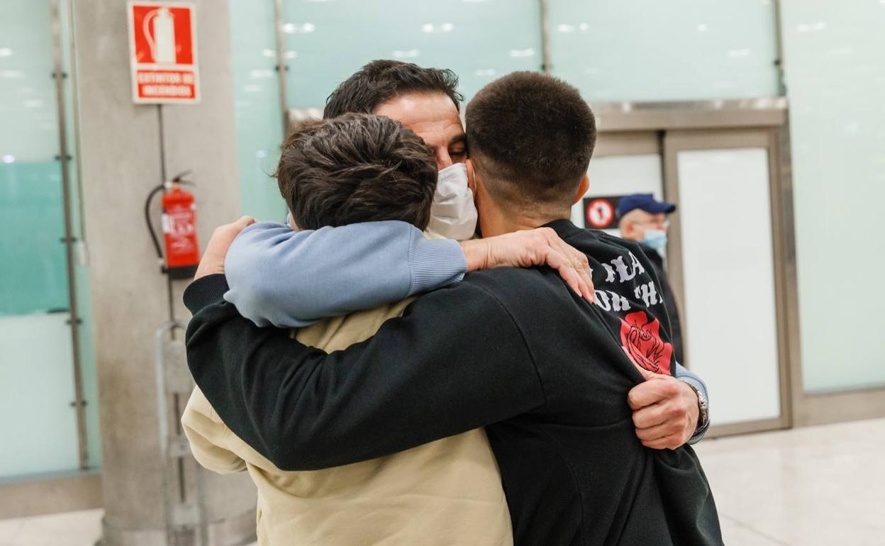 Jorge López se abraza con sus hijos en el aeropuerto de Barajas.