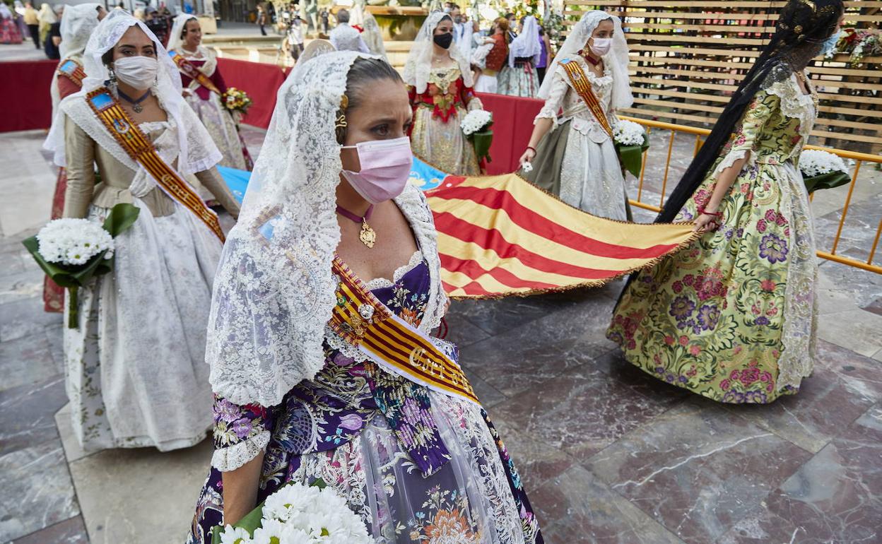 Varias falleras llevando las flores a la Virgen en la Ofrenda. 