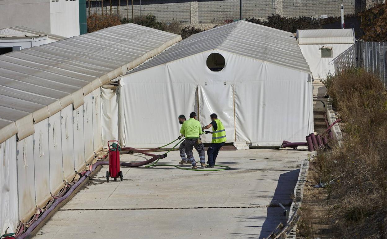 Operarios en el inicio del desmontaje del hospital de campaña ubicado junto a La Fe de Valencia.