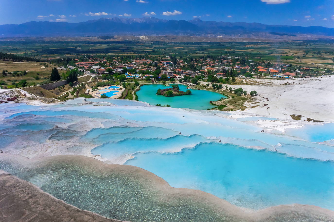 6.- Pamukkale (Denizli, Turquía) | Esta fantasía natural es la principal atracción turística de la región de Anatolia. Cada año atrae a millones de visitantes debido a sus piscinas naturales, de un blanco inmaculado y con aguas de un intenso color verde esmeralda que vierten, como una inmensa cascada pétrea, hacia el valle inferior.