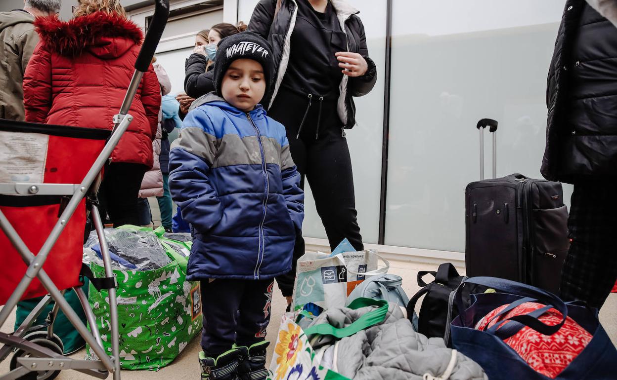 Un niño refugiado rodeado de equipaje a su llegada a Madrid. 