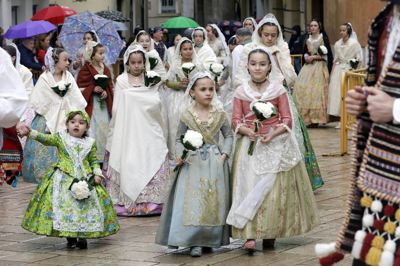 La lluvia no ha podido con el fervor a la Virgen de los Desemperados. La primera jornada de la ofrenda de las Fallas está pasada por agua y protagonizada por las flores y los paraguas, pero nada detiene la ilusión de los falleros de desfilar hasta la Mare de Déu. 